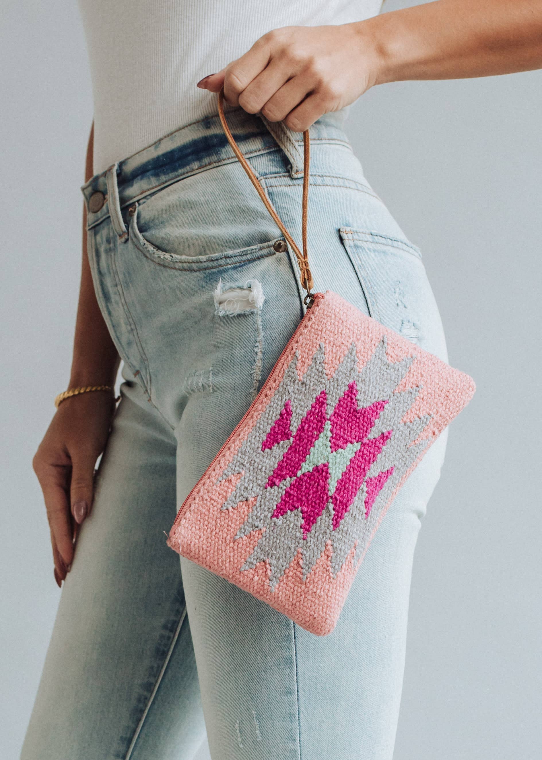 Pastel pink woven wristlet with bold fuchsia, mint, and gray geometric diamond pattern
