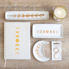 A beautiful stoneware incense holder featuring a moon phase design with a wax resist finish, giving it a handmade feel.