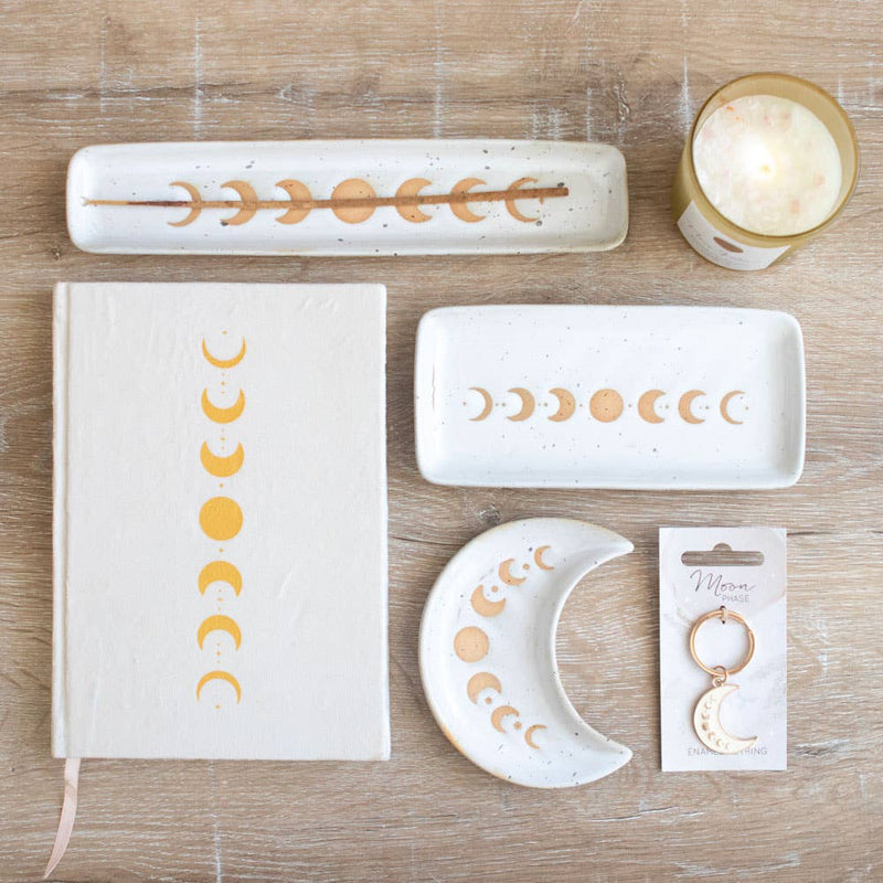 A beautiful stoneware incense holder featuring a moon phase design with a wax resist finish, giving it a handmade feel.