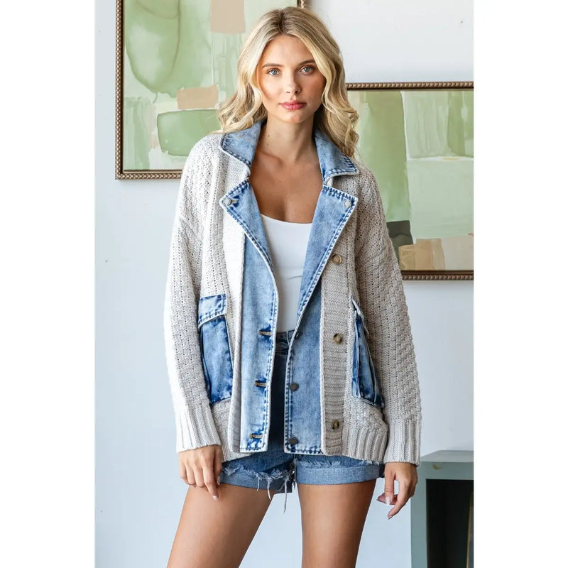 Woman wearing a knit button-up jacket with denim lapel and pocket trim over a white top and denim shorts.