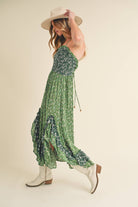 Panoramic view of the enchanting Deeane Ruffle Dress in vibrant green with floral pattern.
