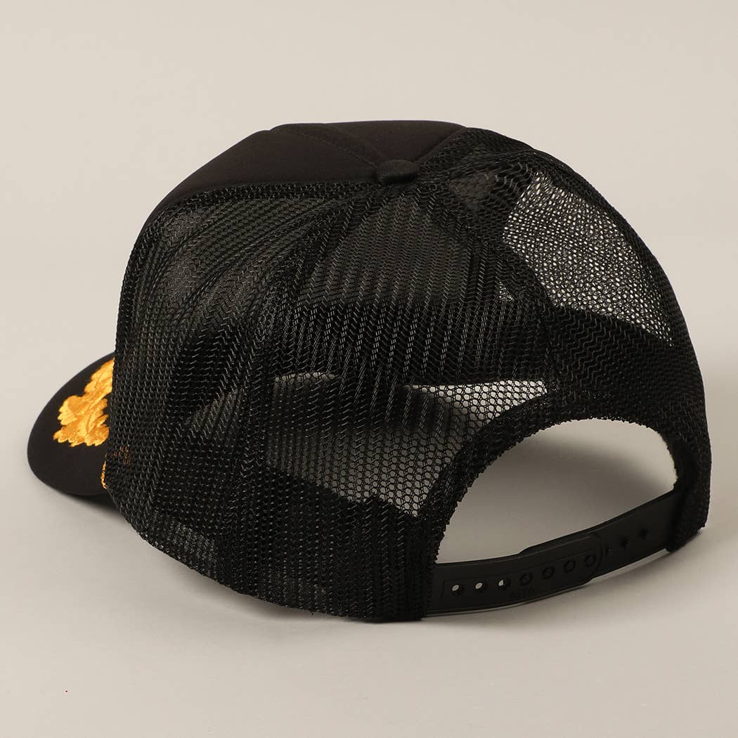 Black mesh cap with a gold logo on a beige background