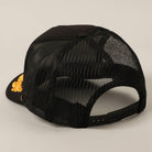 Black mesh cap with a gold logo on a beige background