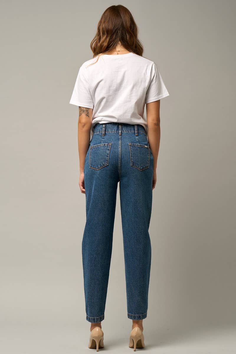  Model wearing high-waist balloon jeans with a relaxed silhouette and slightly tapered legs, paired with a casual graphic t-shirt and neutral heels.