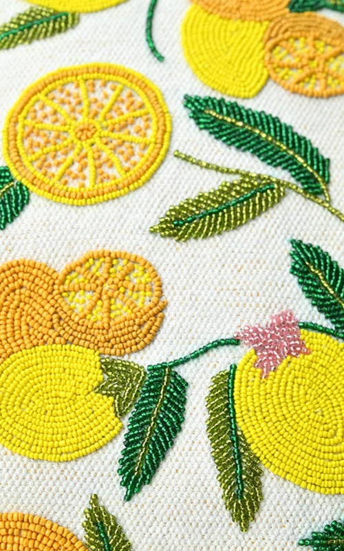 Embroidered handbag with lemons, oranges, and green leaves, featuring a round woven handle and yellow shoulder strap.
