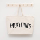 Coral tote bag with “Sunshine Appreciation Society” in white lettering, carried by a woman in a rust-colored embroidered dress