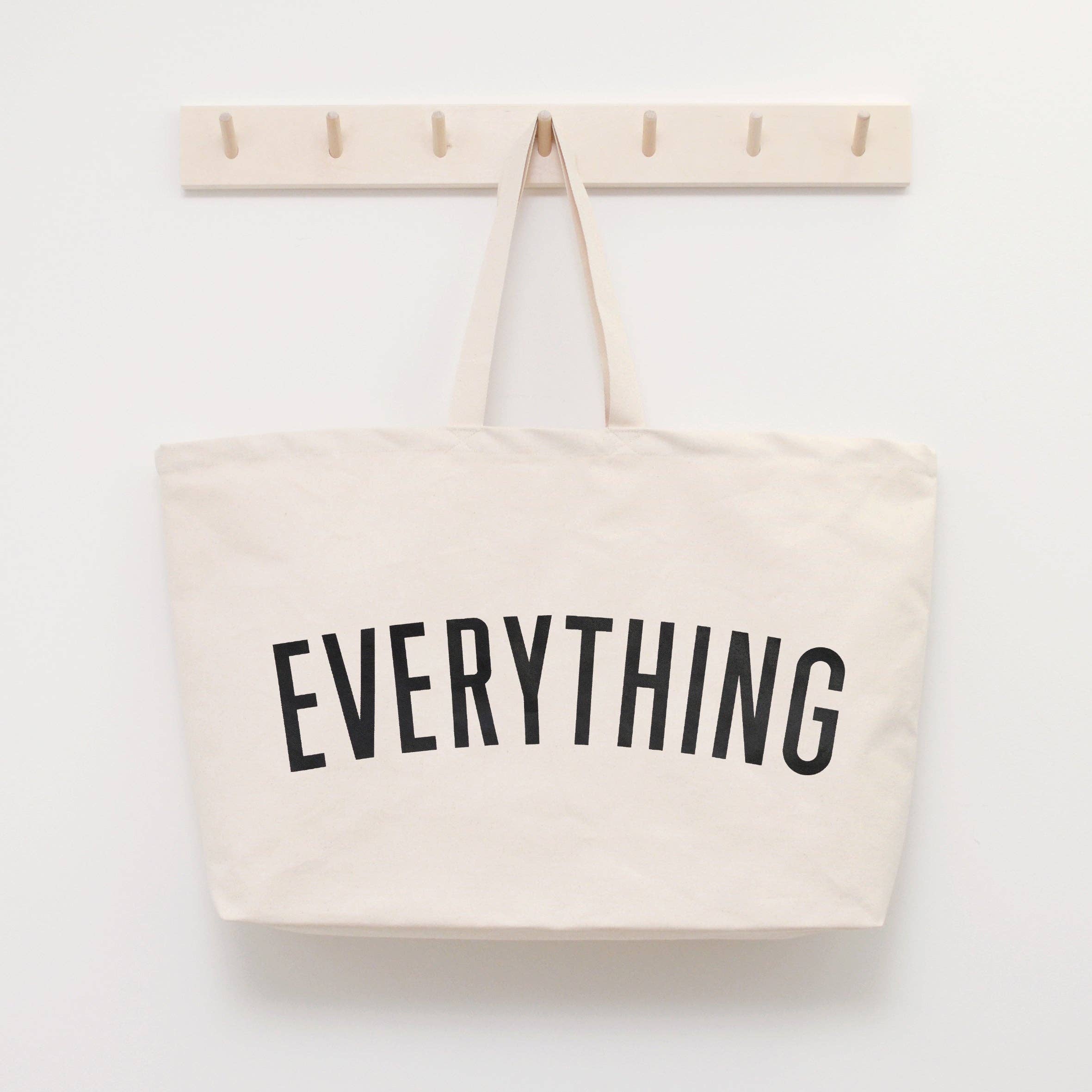 Coral tote bag with “Sunshine Appreciation Society” in white lettering, carried by a woman in a rust-colored embroidered dress