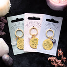 Clear quartz crystal keychain with gold-tone pendant and inspirational message on display card.