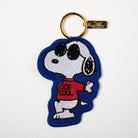 Embroidered keychain with a relaxed character wearing sunglasses and a red sweater, attached to a gold keyring.