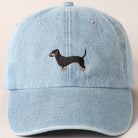 Light blue denim cap with embroidered dachshund on a beige background