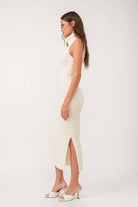 Woman wearing a sleeveless white turtle neck rib-knit midi dress.
