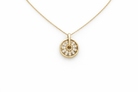Gold necklace with a round pendant on a white background