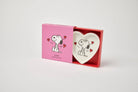 Heart-shaped ceramic trinket dish with a black-and-white illustration of a smiling beagle, accented by red hearts, alongside a matching pink gift box.
