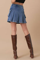 A-line utility denim skirt with large side pockets and button detail, paired with a black crop top.