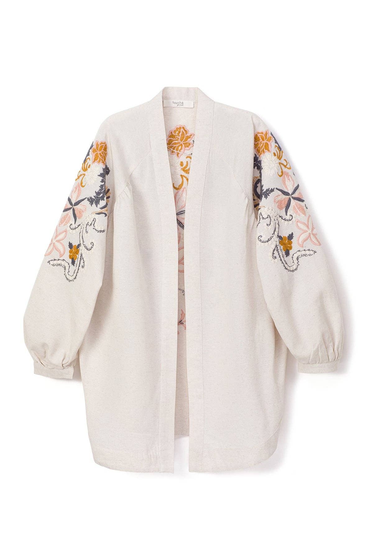 Back view of a cream-colored kimono jacket with colorful floral embroidery, worn with matching light trousers.