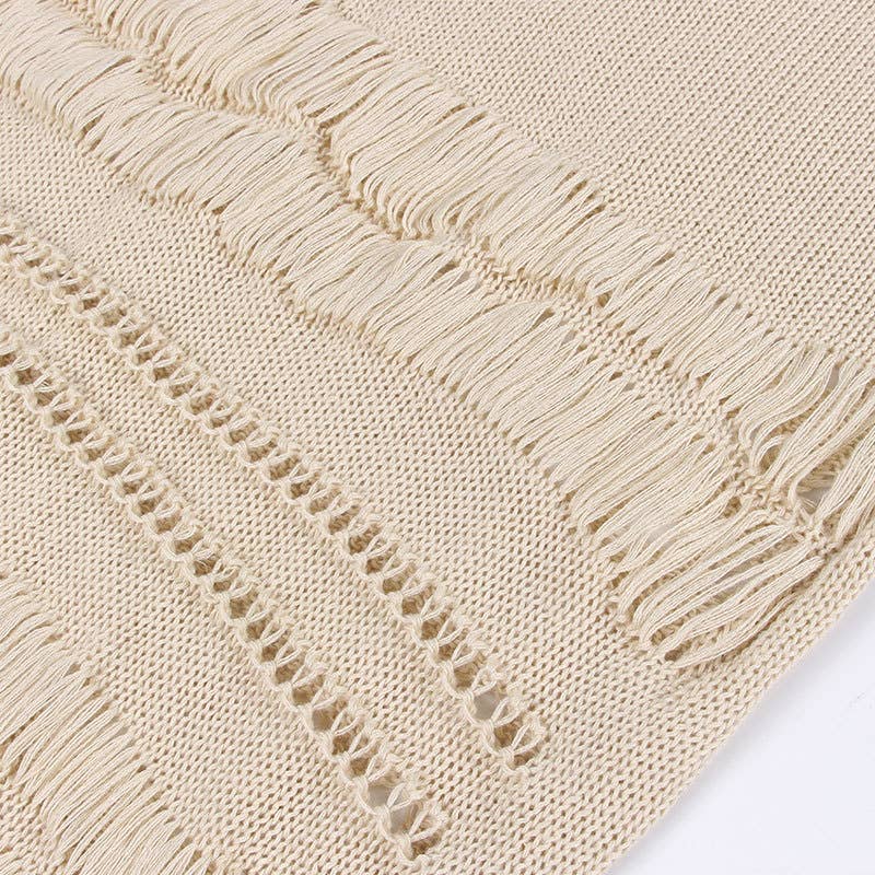 Woman wearing a Seaside Serenity Crochet Cover-Up Dress with a crochet design, adjustable spaghetti straps, and a fringe hem.