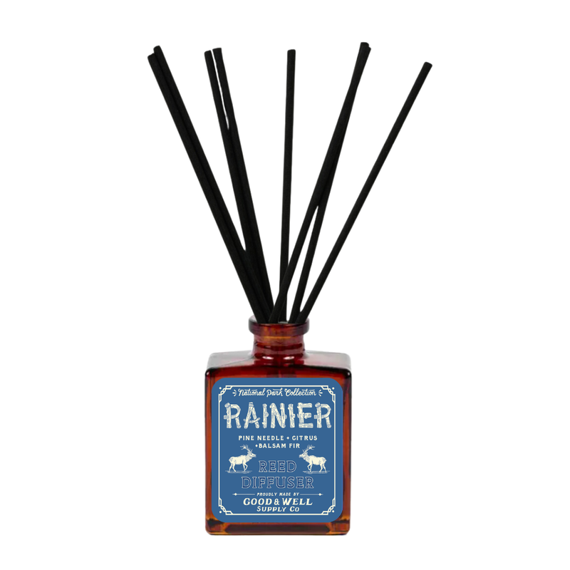 Rainier reed diffuser with amber glass bottle and black reeds by Good & Well Supply Co., featuring pine, citrus, and fir scents.