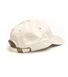 Beige baseball cap with embroidered whiskey glass and cigar design on the front.