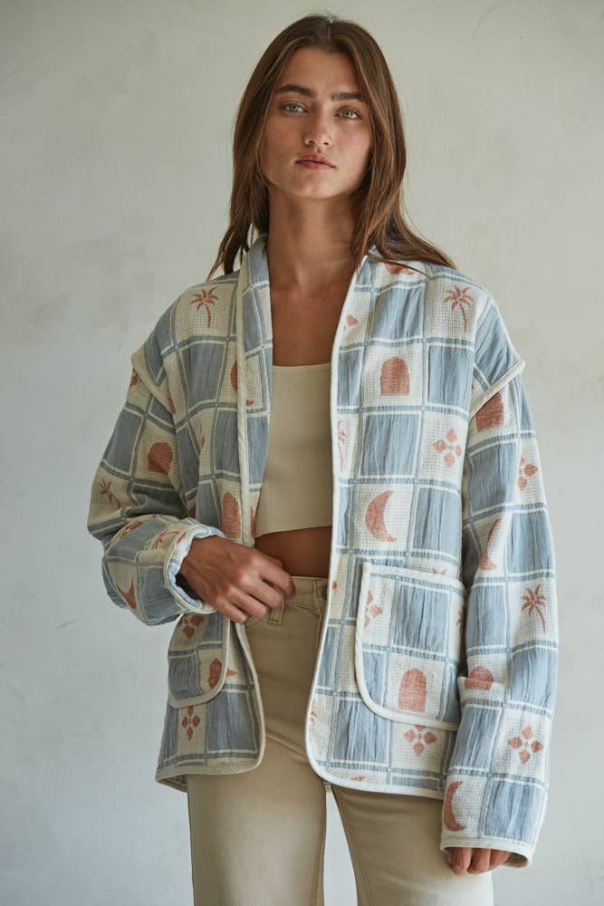 Quilted cotton jacket with desert-themed motifs and soft blue, cream, and terracotta tones