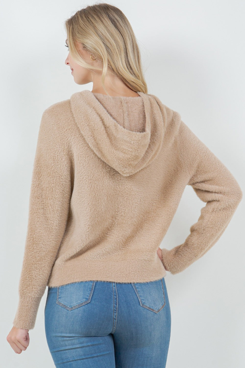 Woman wearing a beige ultra-soft hoodie with a drawstring hood.