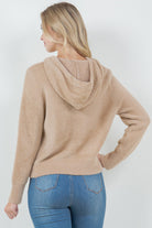 Woman wearing a beige ultra-soft hoodie with a drawstring hood.
