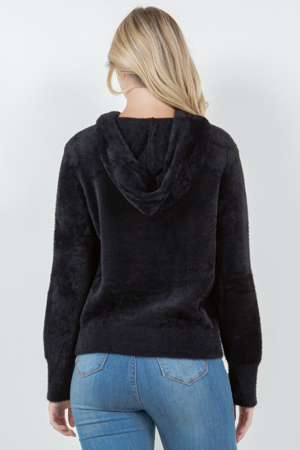 Woman wearing a black ultra-soft hoodie with a drawstring hood.