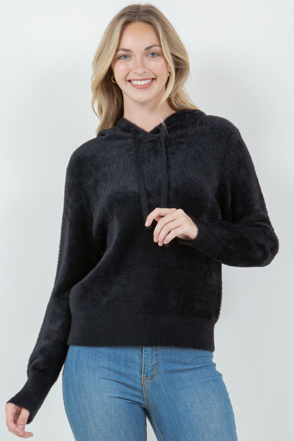 Woman wearing a black ultra-soft hoodie with a drawstring hood.