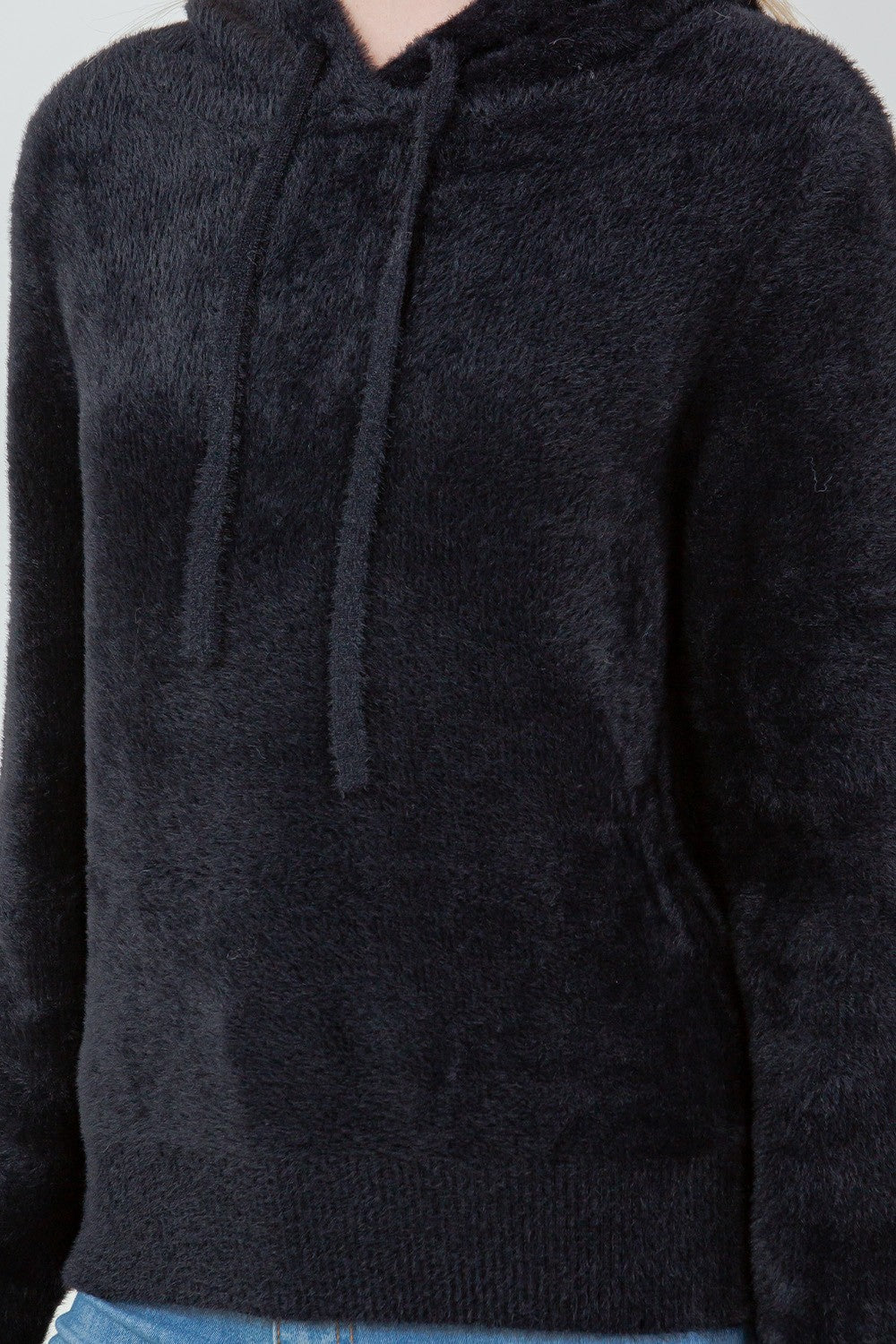 Woman wearing a black ultra-soft hoodie with a drawstring hood.