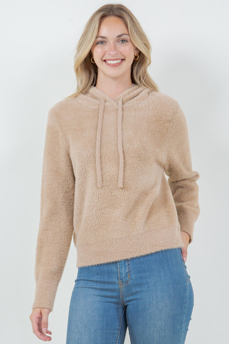 Woman wearing a beige ultra-soft hoodie with a drawstring hood.