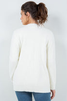 Woman wearing a soft white open-front cardigan with pockets.