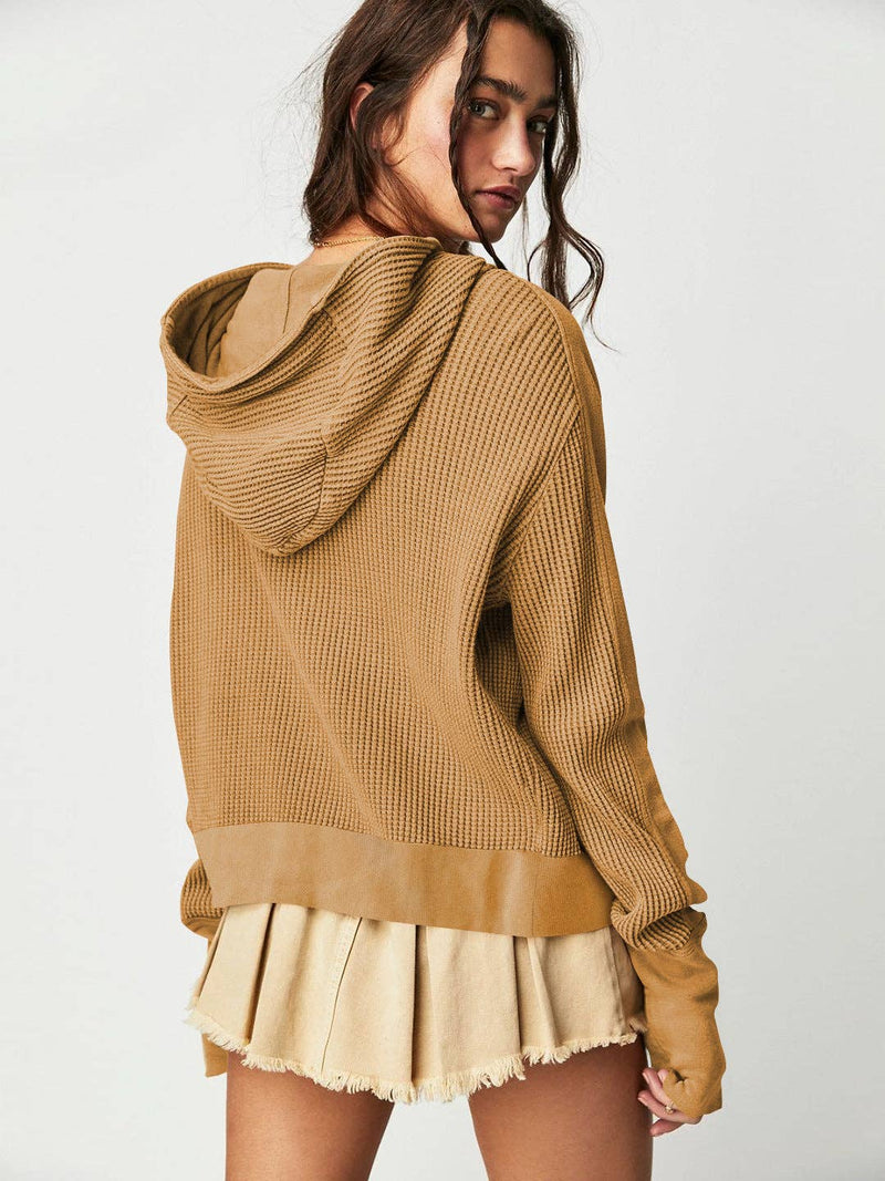 Woman wearing a Sahara Sky Hooded Jacket with a zip-up front, textured waffle knit, and button detailing in blue and brown tones.