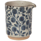 Ceramic pitcher with blue floral pattern on a white background