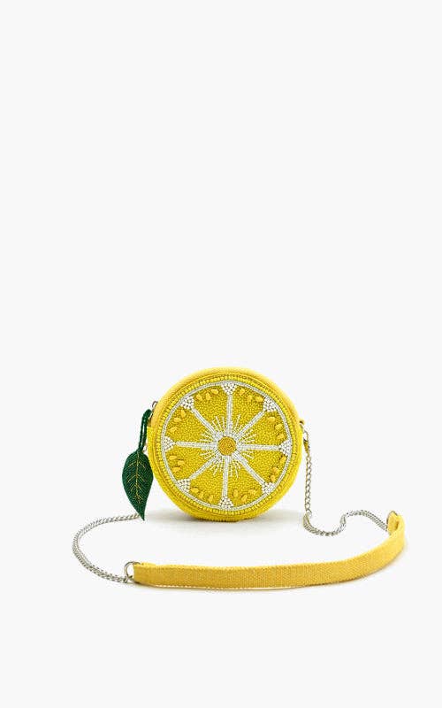 Round beaded lemon slice crossbody bag with silver chain strap and green leaf charm accent.