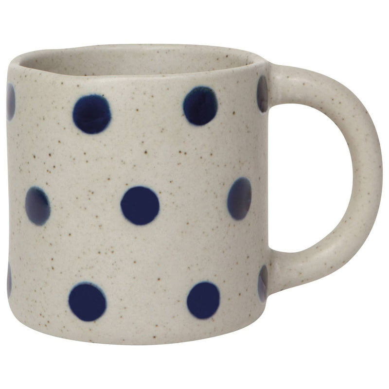 White mug with blue polka dots on a white background