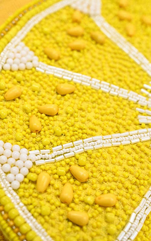 Yellow lemon slice-shaped bag with beaded detailing and a matching twisted rope shoulder strap.