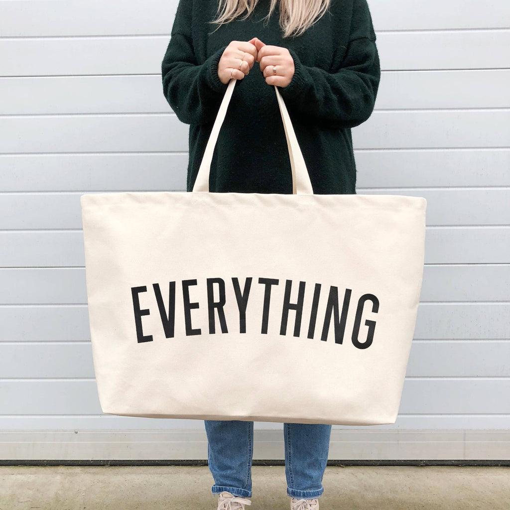 Coral tote bag with “Sunshine Appreciation Society” in white lettering, carried by a woman in a rust-colored embroidered dress