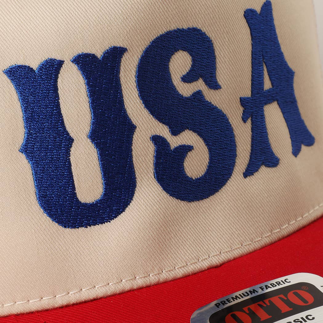 Close-up of a cap with 'USA' embroidered in blue on a beige background.