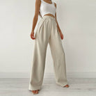 Woman wearing Urban Elegance Palazzo Pants in cream color with a white crop top.