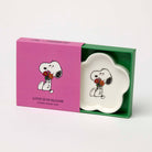 Flower-shaped ceramic trinket dish featuring a black-and-white beagle holding a bouquet of red and orange flowers, packaged in a pink and green gift box.