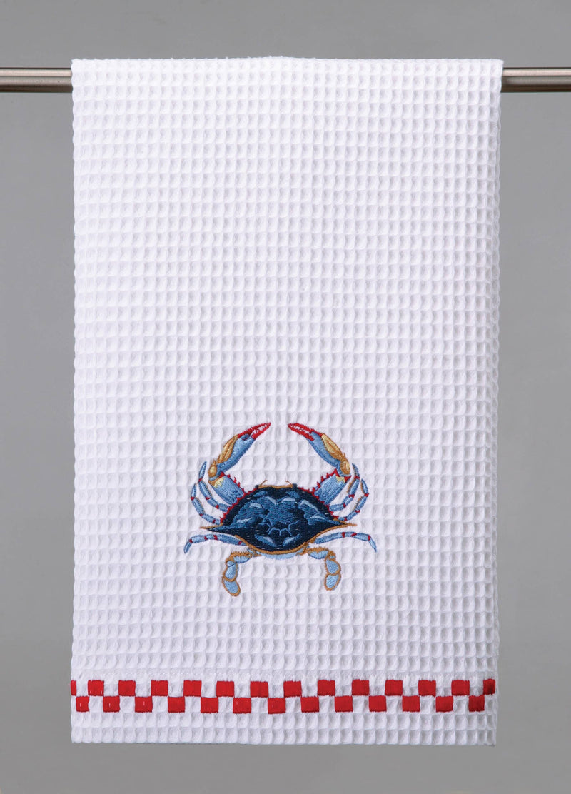 A white waffle weave kitchen towel with an embroidered blue crab design and red checkered trim.