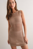 Woman wearing a sleeveless black crochet mini dress.