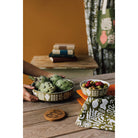 Olympus Imprint Bowl featuring early Greek ceramic motifs in pale designs on an earthy brown surface.