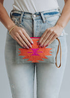 Woven wristlet pouch with gray background and bright orange and magenta lightning bolt design
