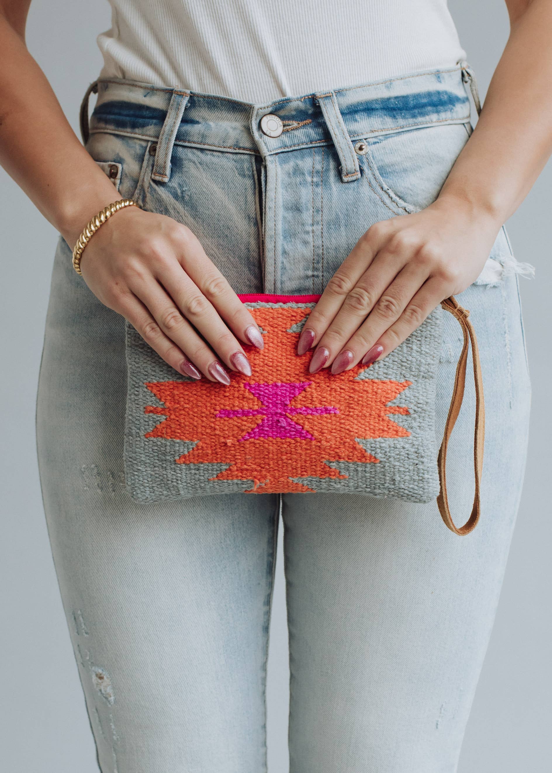 Woven wristlet pouch with gray background and bright orange and magenta lightning bolt design
