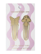 A set of two brass metal page tabs in butterfly and mushroom shapes, packaged on a pastel pink and white wavy background.