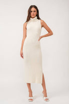 Woman wearing a sleeveless white turtle neck rib-knit midi dress.