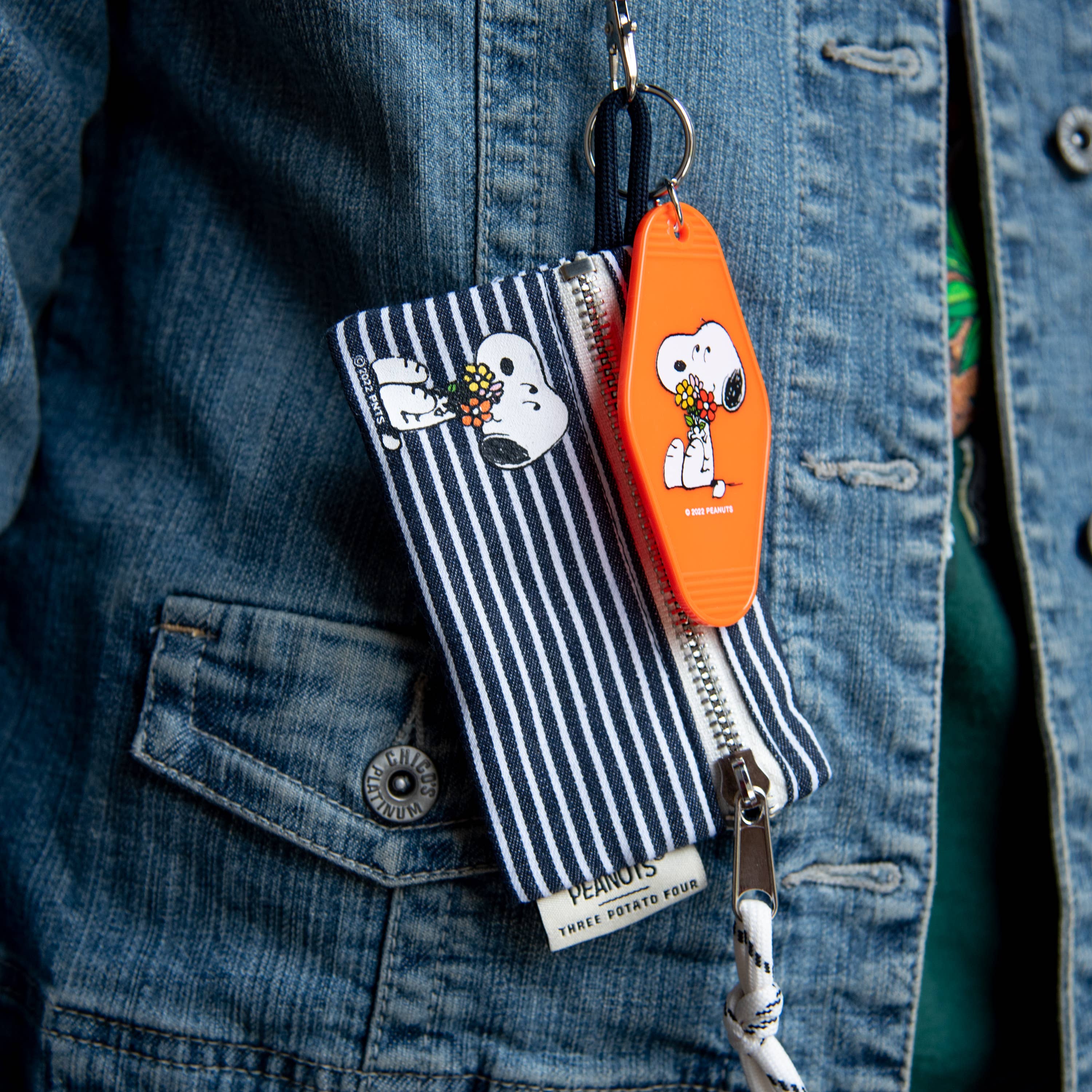 Peanuts® Snoopy Flower Bouquet Key Tag featuring Snoopy holding a bouquet of colorful flowers on a vibrant orange background.