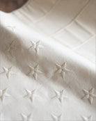 Close-up of a textured white fabric with embossed star patterns