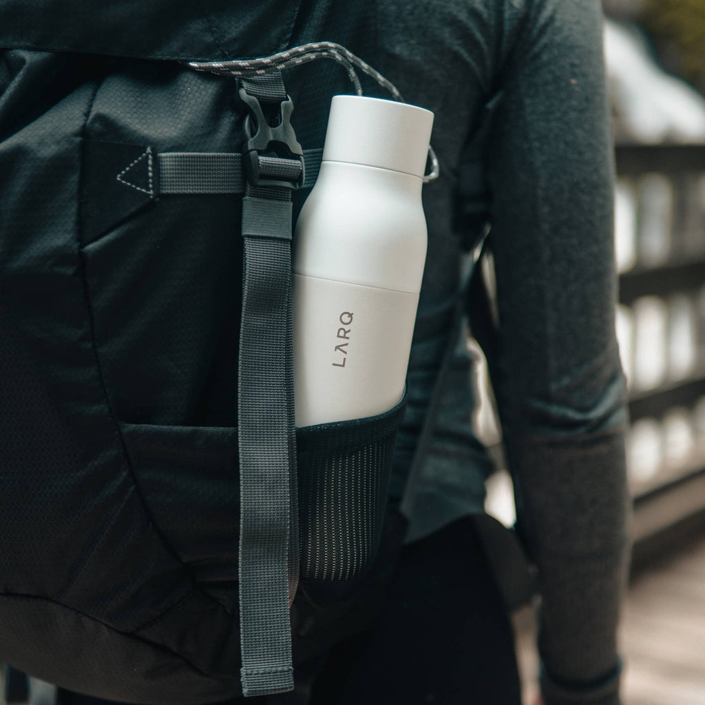 LARQ white water bottle with UV-C LED cap active, floating on a white background.