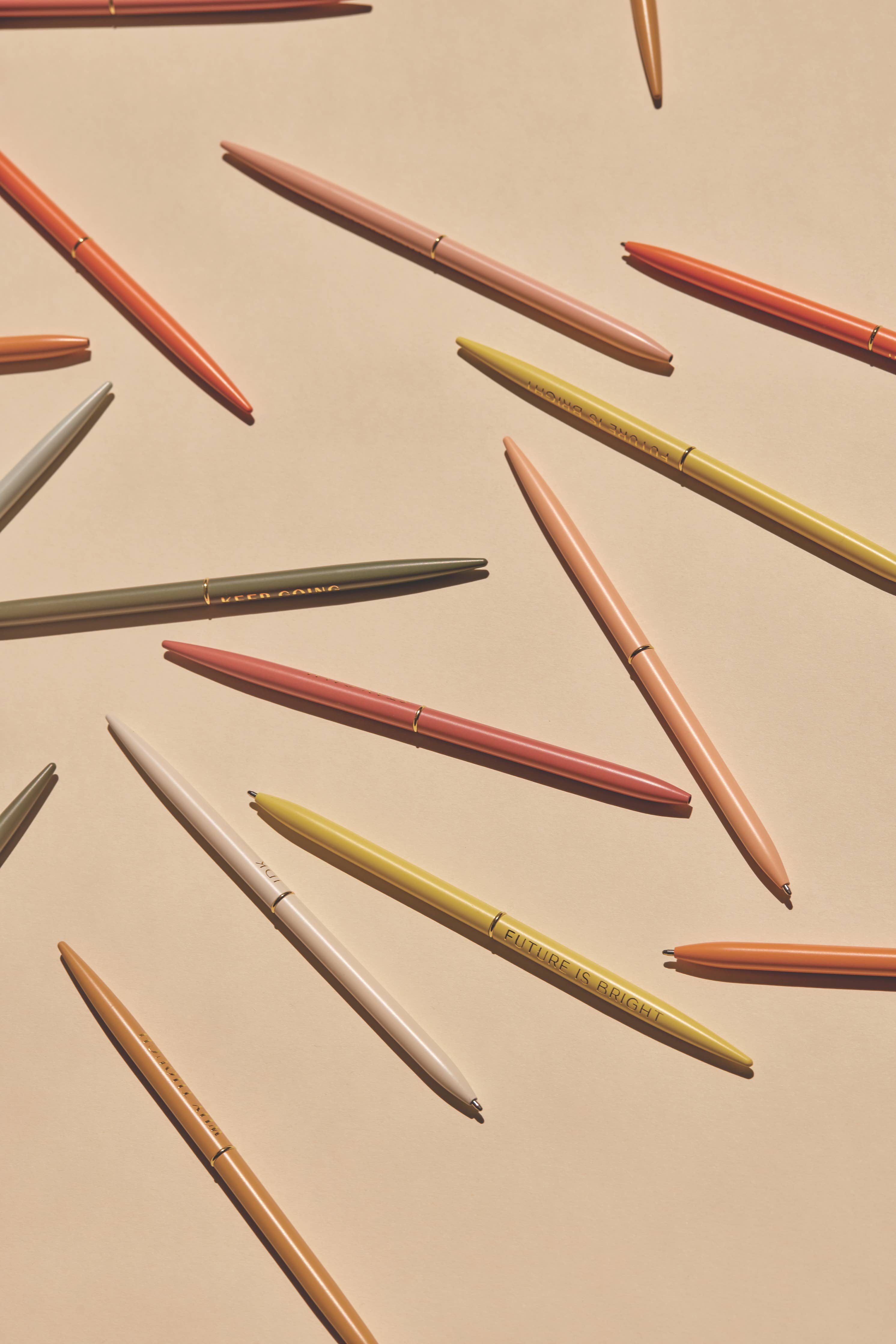 "Positivity" slim metal pen set of four in assorted bright colors, each featuring an inspirational message, packaged in a mint green box.